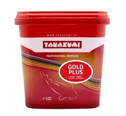 Czerwone wiadro karmy dla ryb Koi marki Takazumi. Na froncie znajduje się biały napis "TAKAZUMI PROFESSIONAL KOIFOOD" oraz czerwony okrąg z napisem "GOLD PLUS". Poniżej widoczny jest biały kontur ryby Koi na kolorowym, tęczowym tle.
